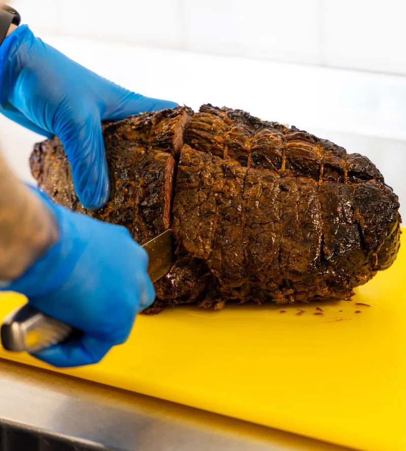 A TNINE chef carving a joint of roast beef