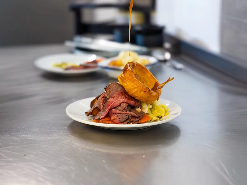 Roast beef and Yorkshire pudding plated on the pass