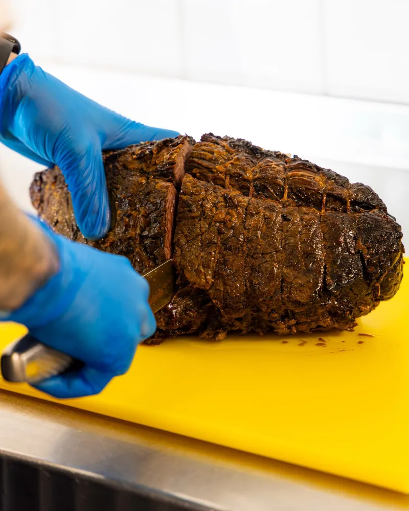 A TNINE chef carving a joint of roast beef