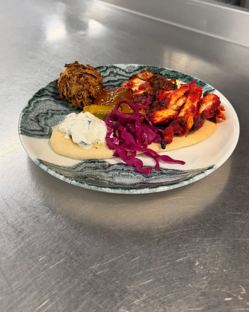 Spiced chicken on a flatbread with tzatziki, pickled red cabbage and chutney
