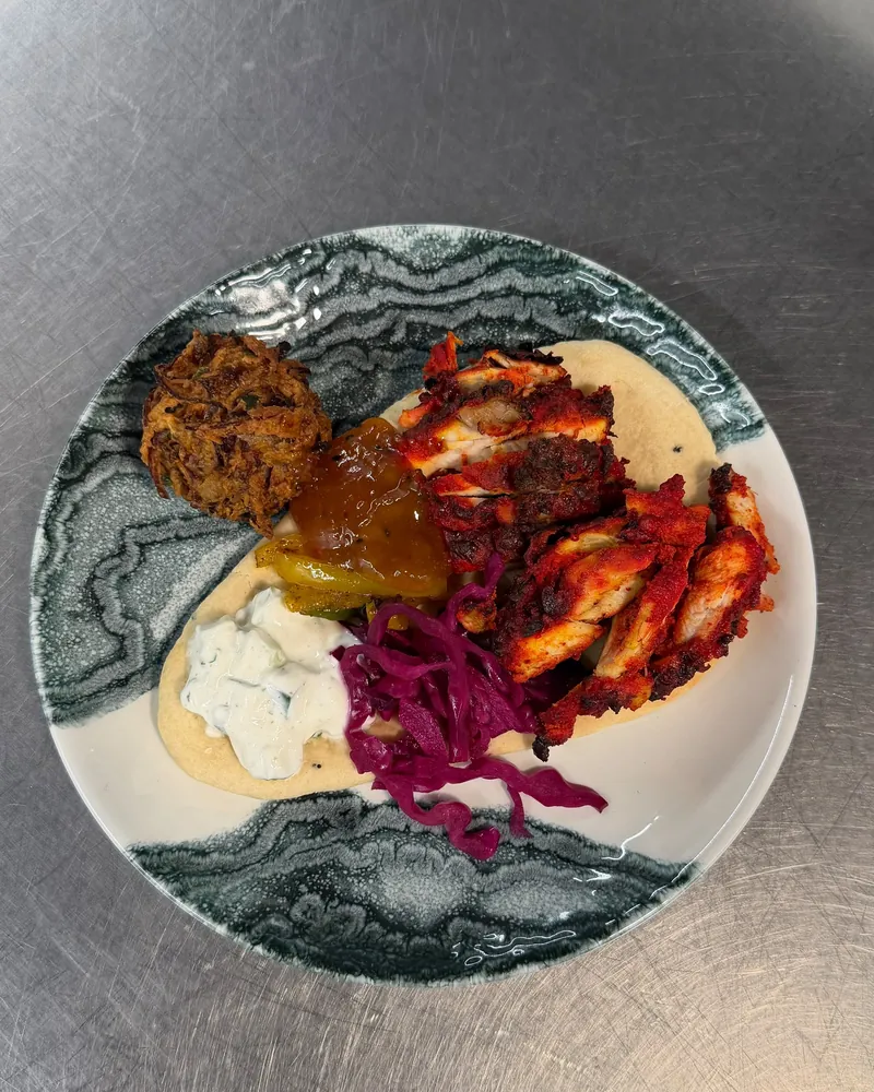 Spiced chicken flatbread with tzatziki, pickled red cabbage and chutney, from above