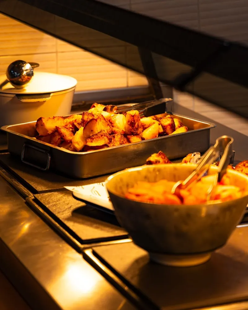 Roast potatoes and carrots on the hot counter