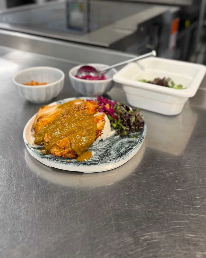 Chicken katsu curry with rice, pickled red cabbage and micro herbs