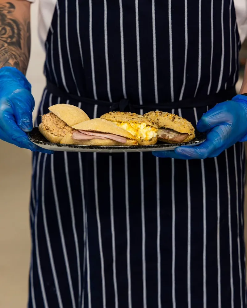 A TNINE chef carrying a tray of freshly filled rolls