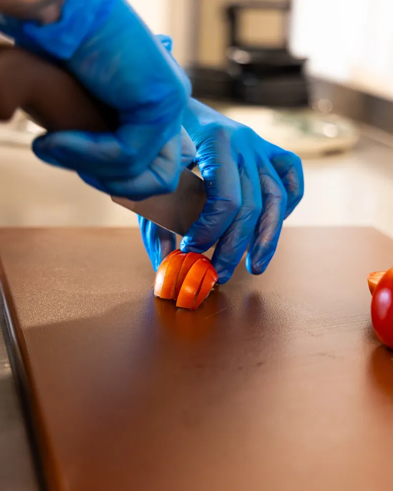 A TNINE chef slicing tomatoes by hand